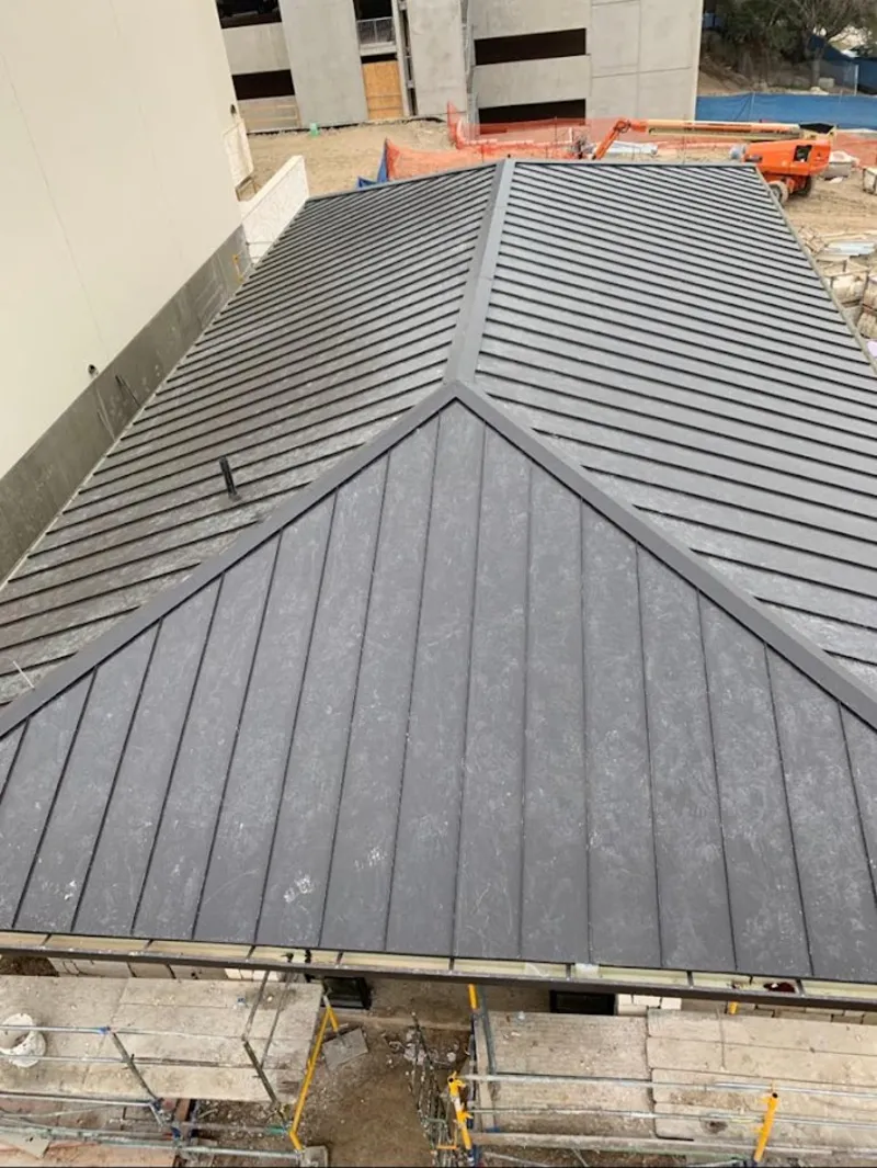 Commercial metal roof construction with crane equipment in Christiana